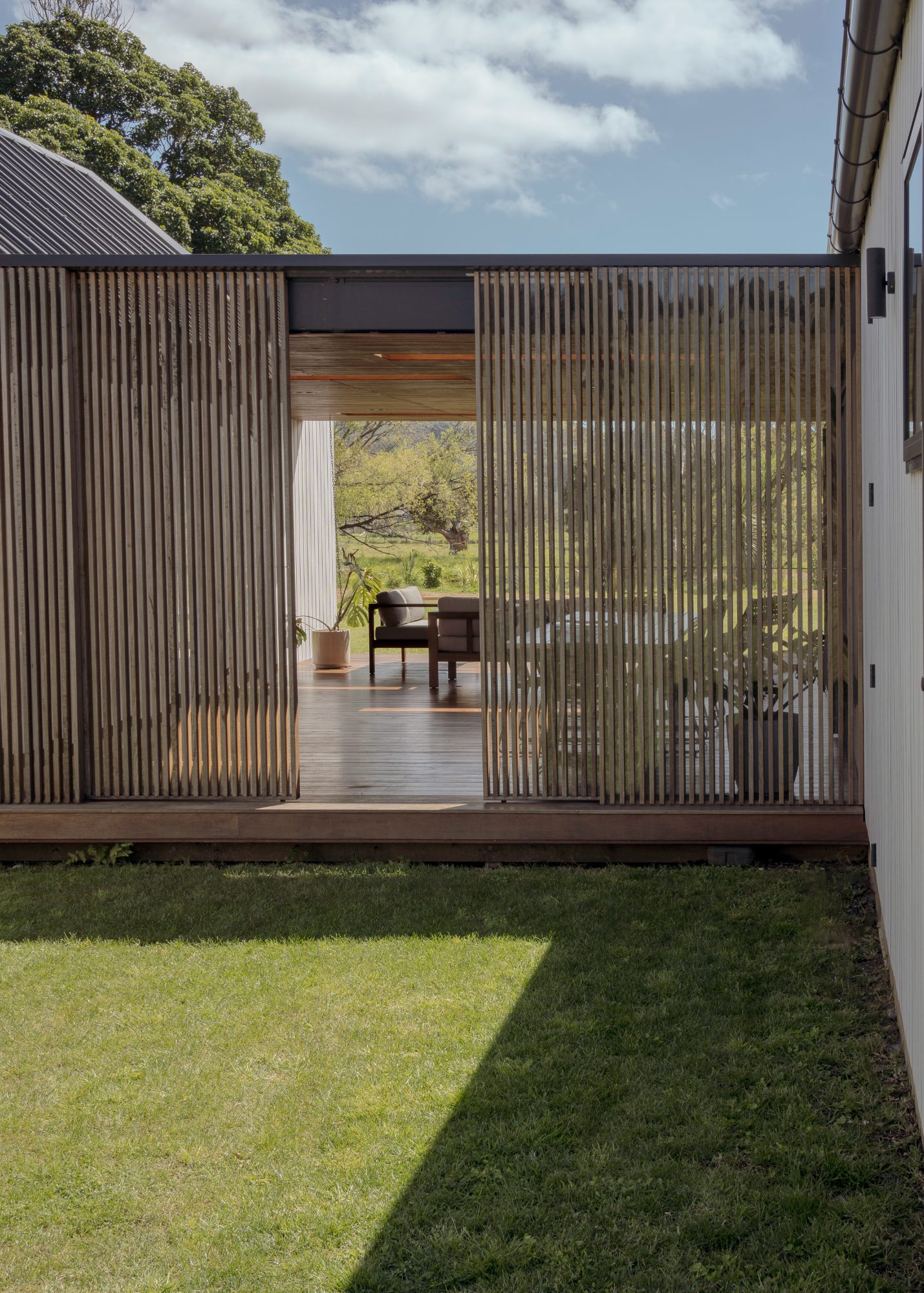 Awa Coastal slatted timber screens framing the outdoor room,  New Zealand architectural photography