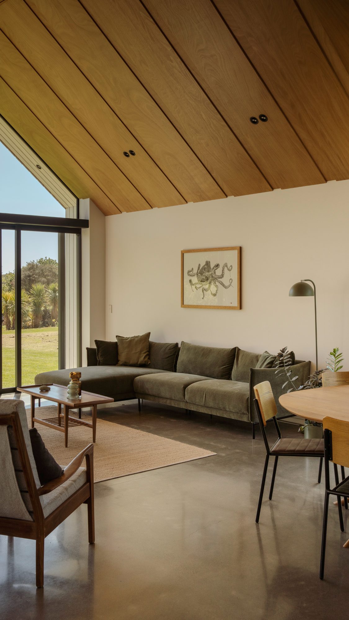 Awa Coastal vaulted living room with green sofa and timber ceiling, Whangapoua interior photography NZ