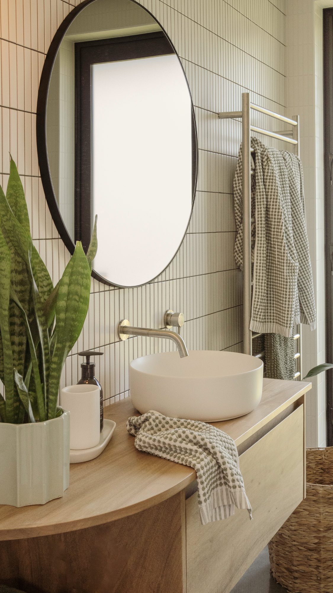 Awa Coastal bathroom vanity with round mirror and tiled wall, Whangapoua interior photography NZ