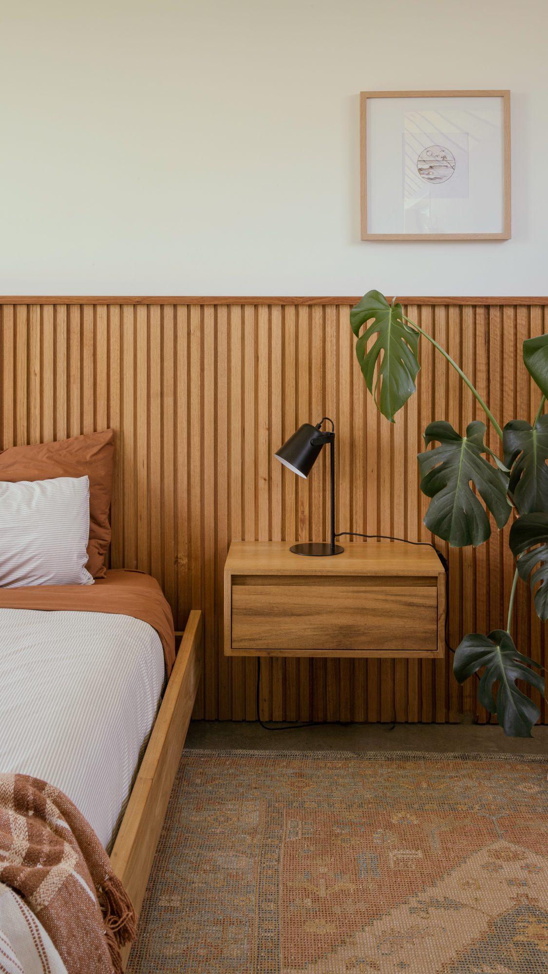 Awa Coastal floating bedside table and lamp on timber panelling, Whangapoua interior photography NZ
