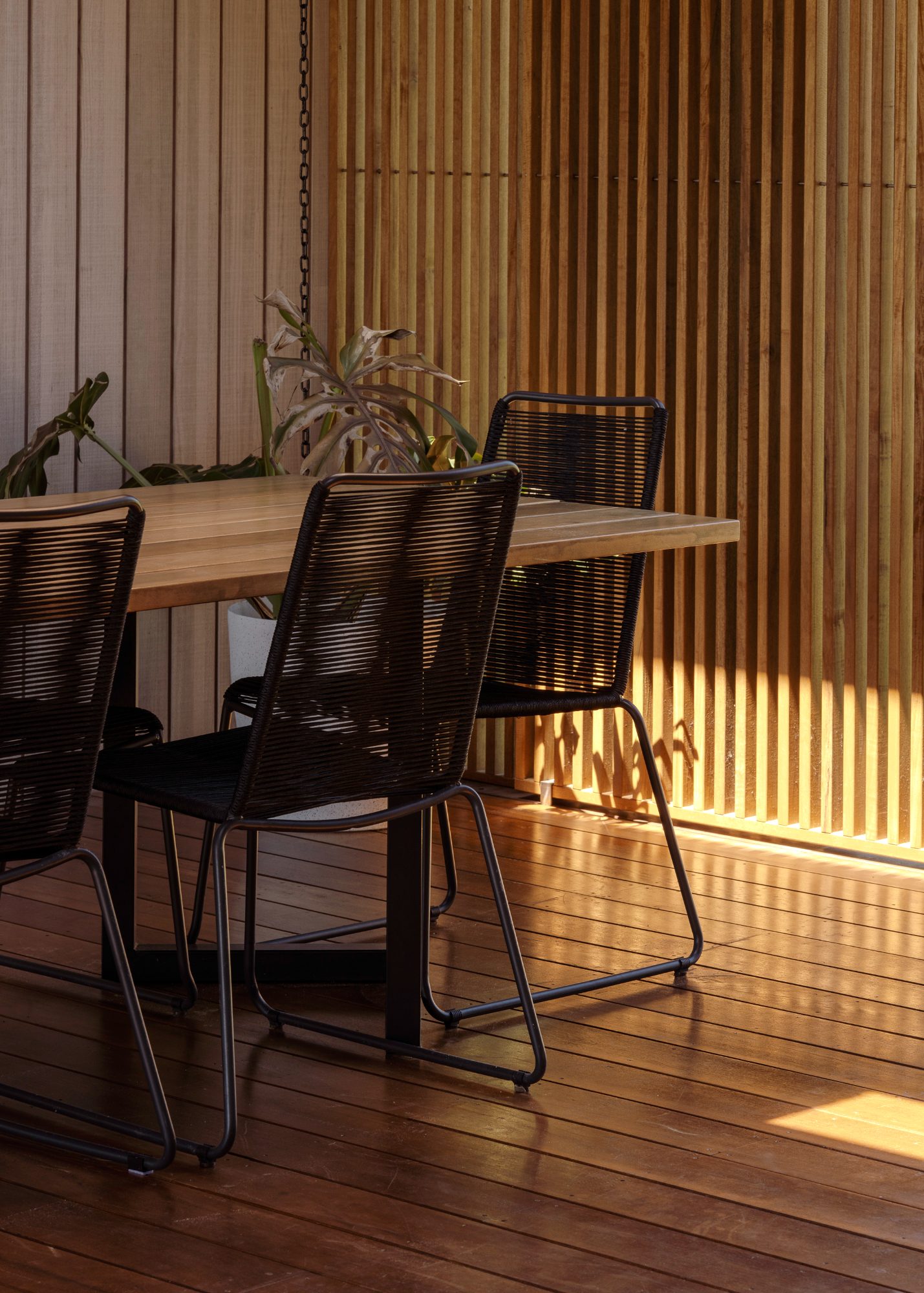 Awa Coastal outdoor dining in late sun beside timber screen, Whangapoua interior photography NZ