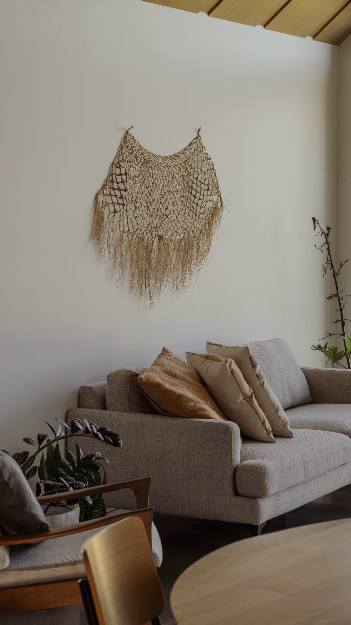 Awa Coastal woven wall hanging above living room sofa, Whangapoua interior photography NZ