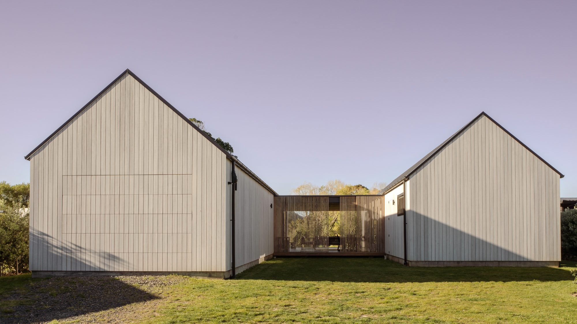 Awa Coastal twin gables and screened courtyard at dusk,  New Zealand architectural photography