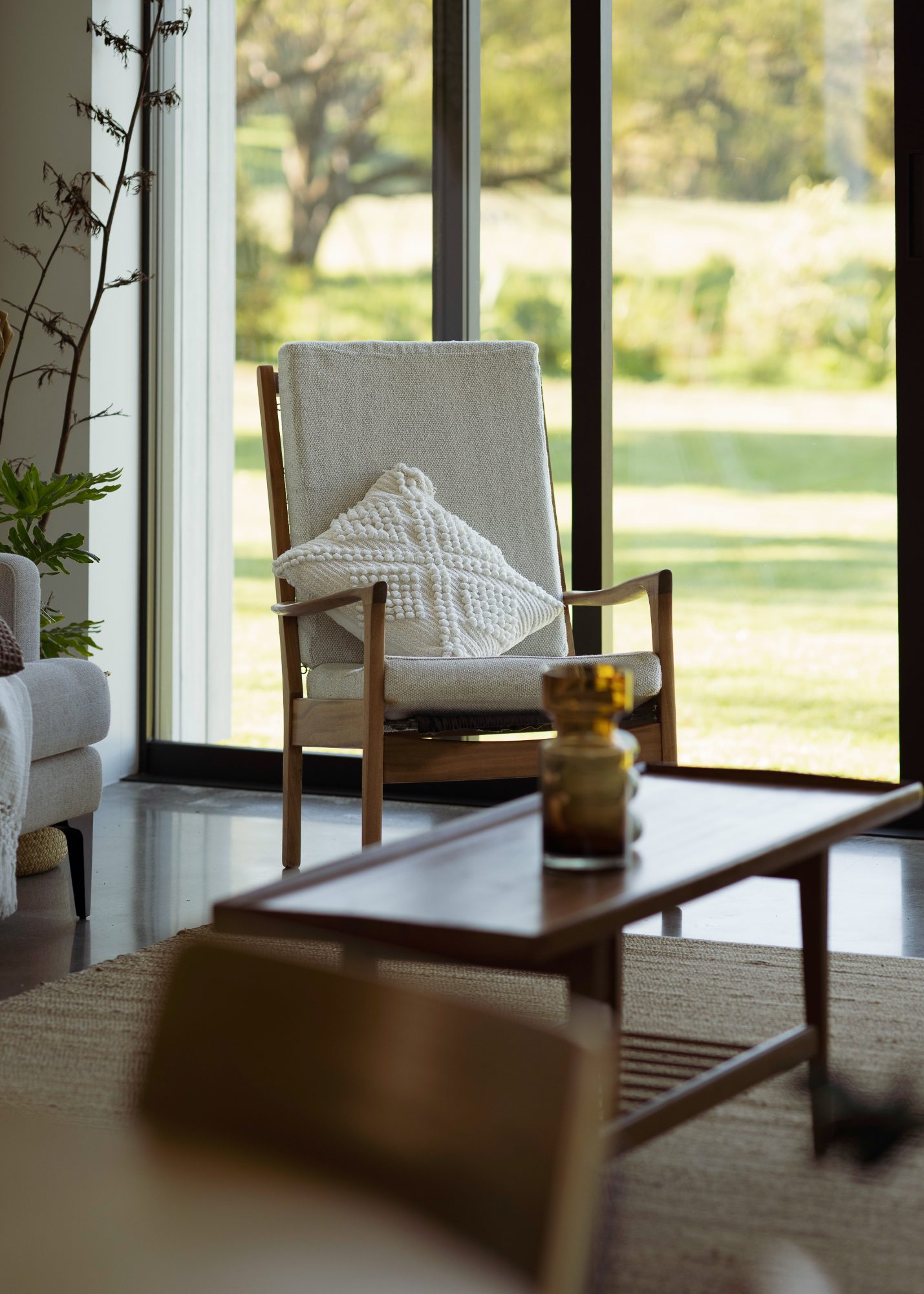 Awa Coastal armchair and coffee table in soft window light, Whangapoua interior photography NZ