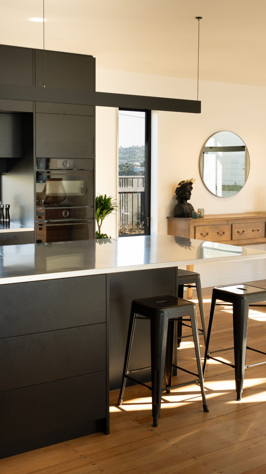 Seatoun Heights kitchen island and dining area in afternoon light, Wellington interior photography NZ