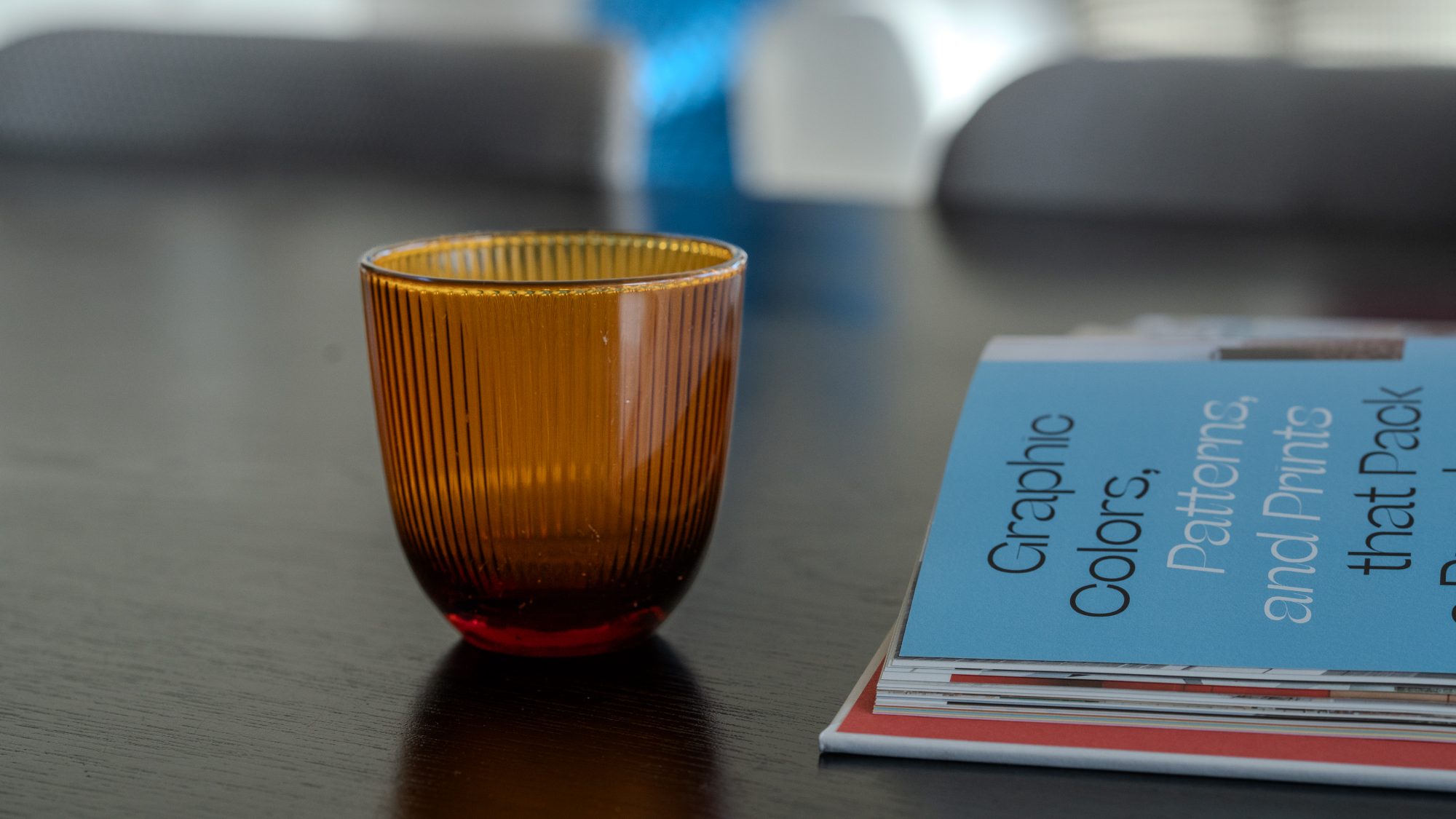 Seatoun House amber ribbed glass and books on dining table, Wellington interior photography NZ