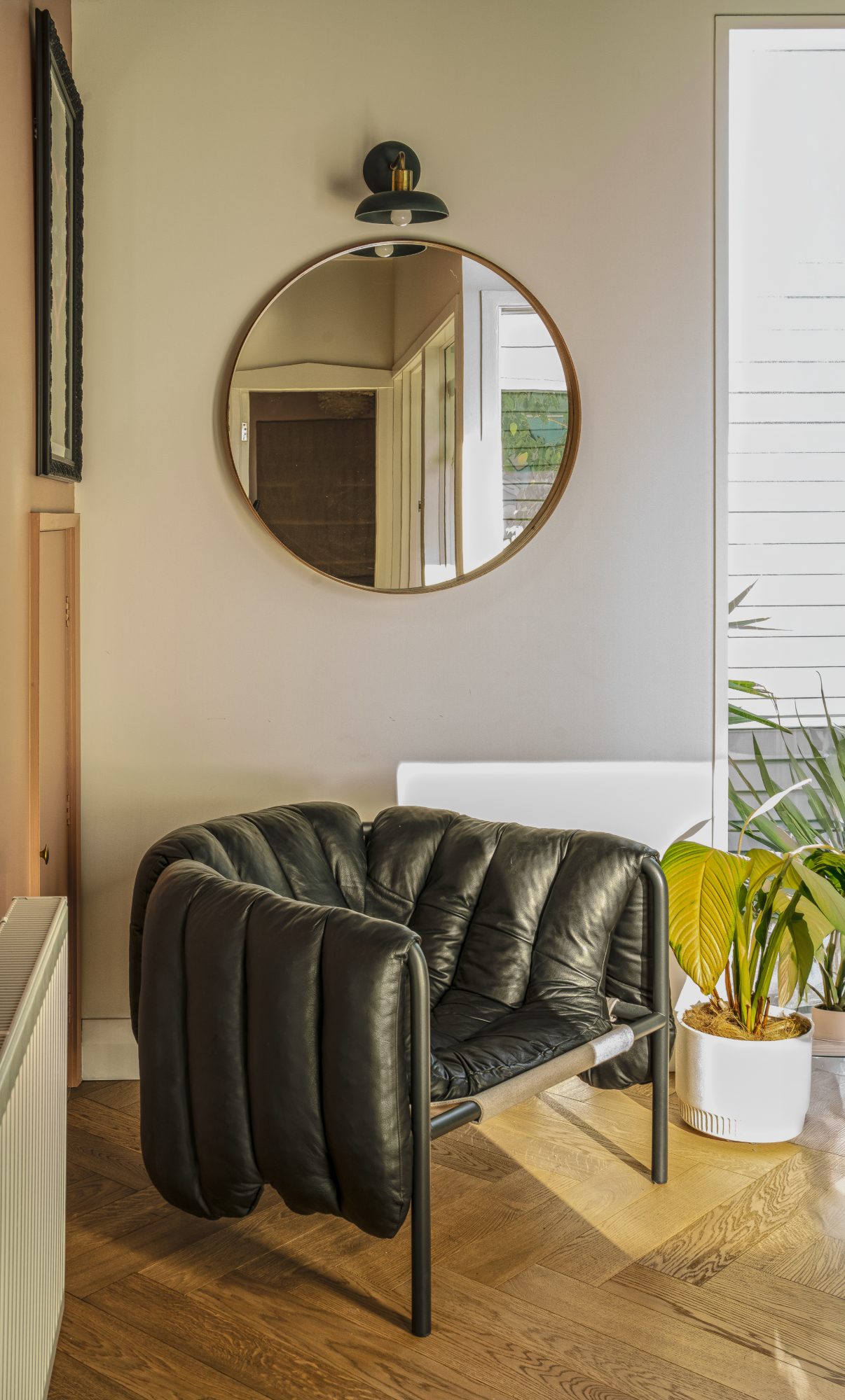 Seatoun House black leather chair and round mirror on herringbone floor, Wellington interior photography NZ